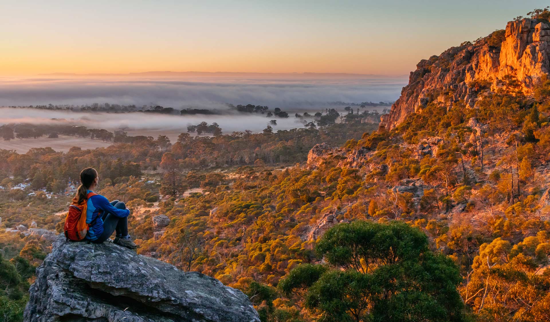 A walker stops to take in the sunrise at Mt Arapiles.
