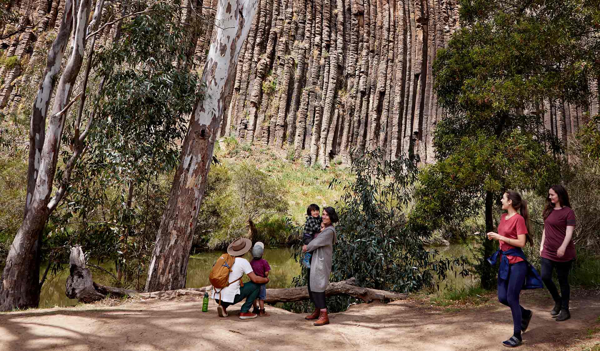 A young family admiring the rock formation at Organ Pipes National Park