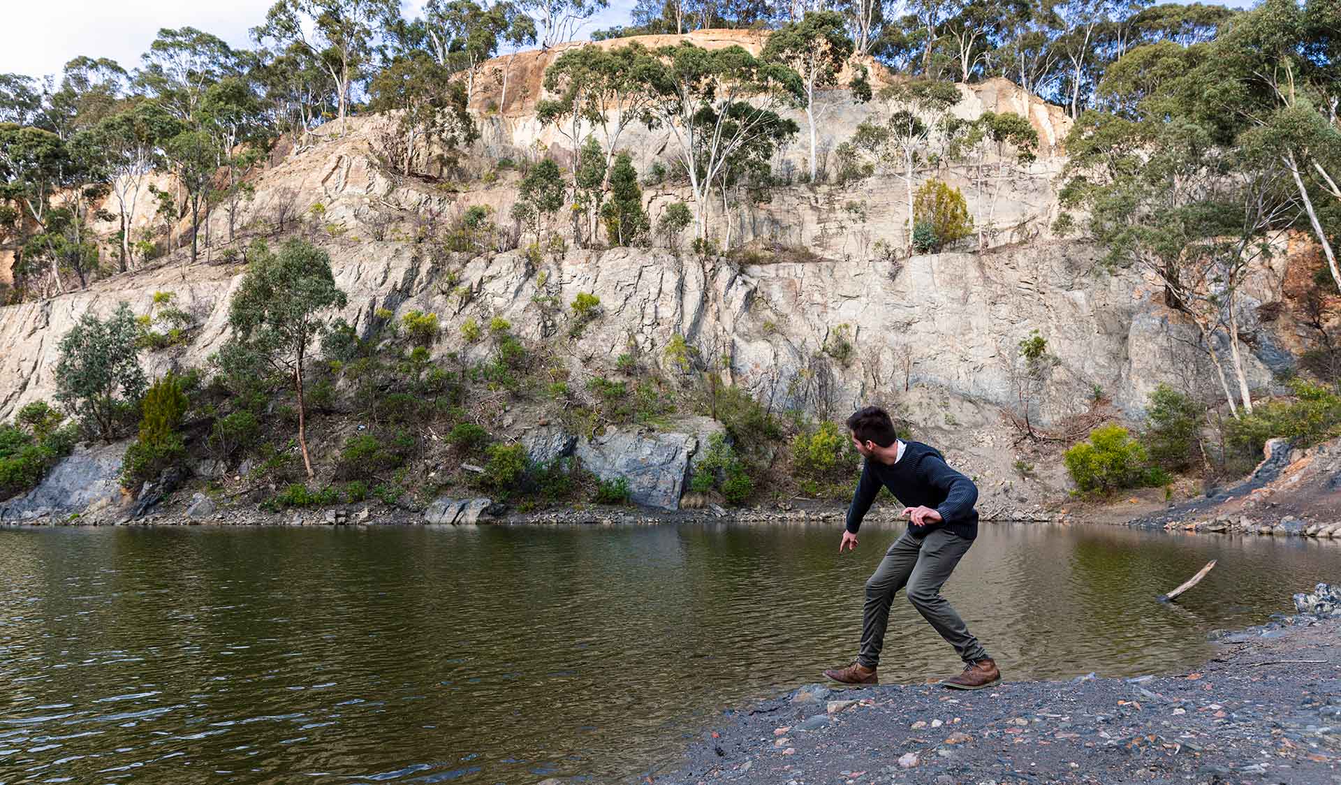 A man skims a rock along the water at Blue Lake at Plenty Gorge Park