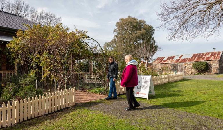 Two friends walk through the gardens in to Le Page Homestead