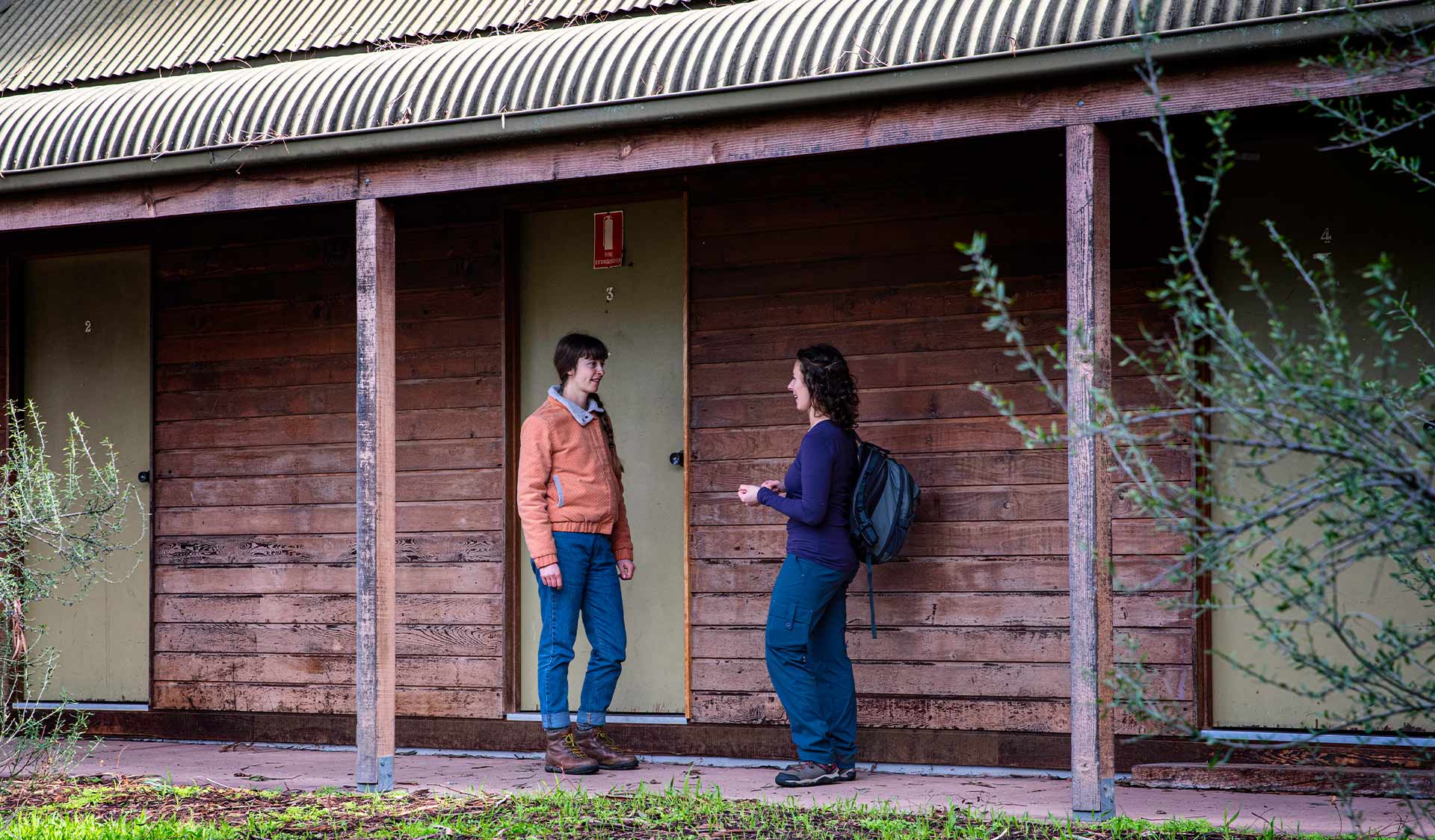 Two women stop for a chat outside the dorm rooms at Nioka Bush Camp.