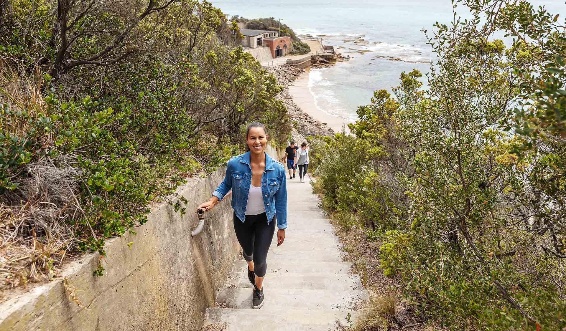 A women walks up the walkway from a beach at Point Nepean National Park. 