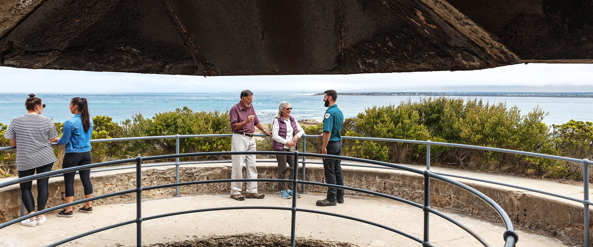 An older couple talk with a Parks Victoria Ranger at a military lookout