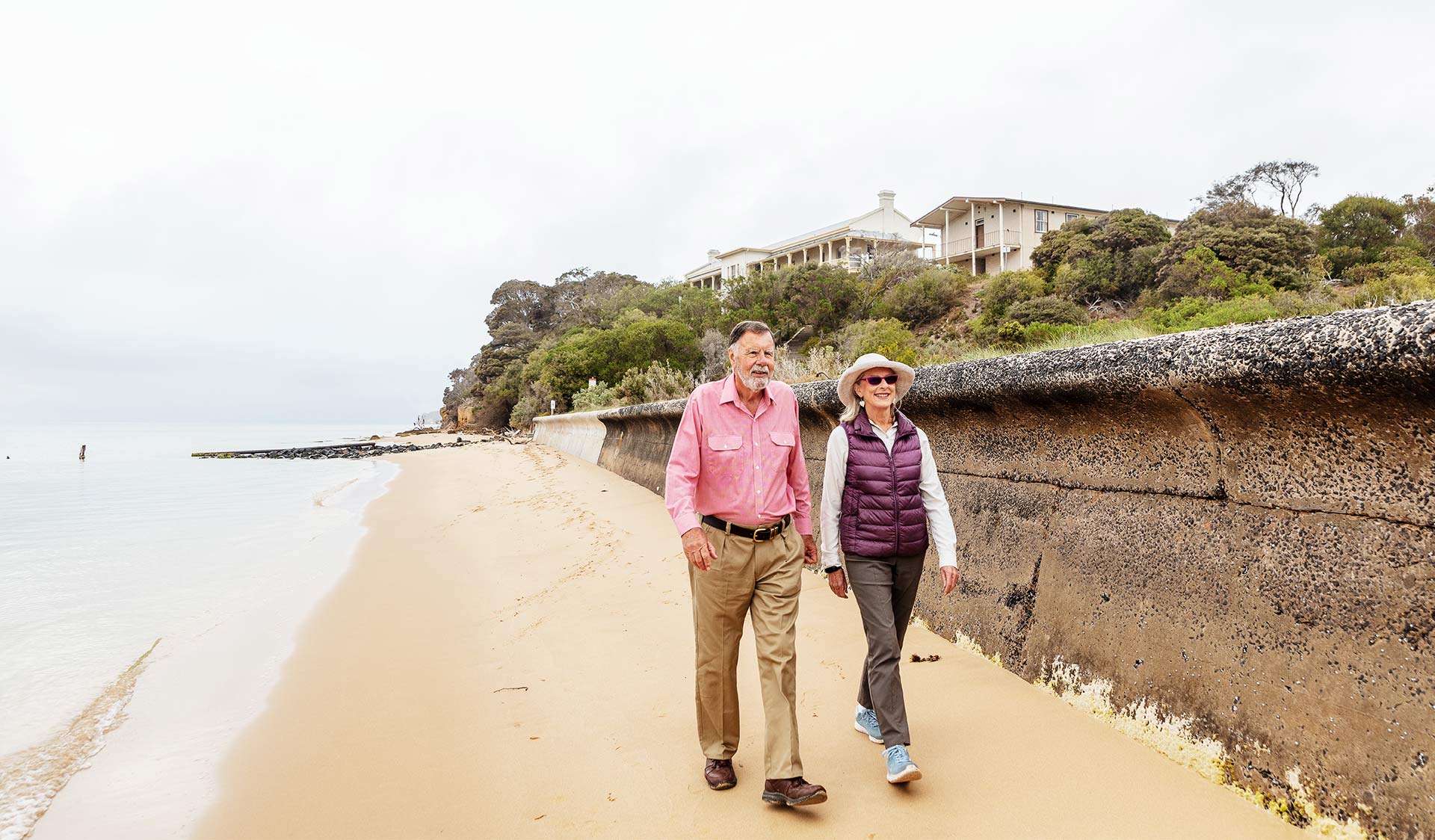 An elderly couple walking along the beach together at the Quarantine Station in Point Nepean National Park