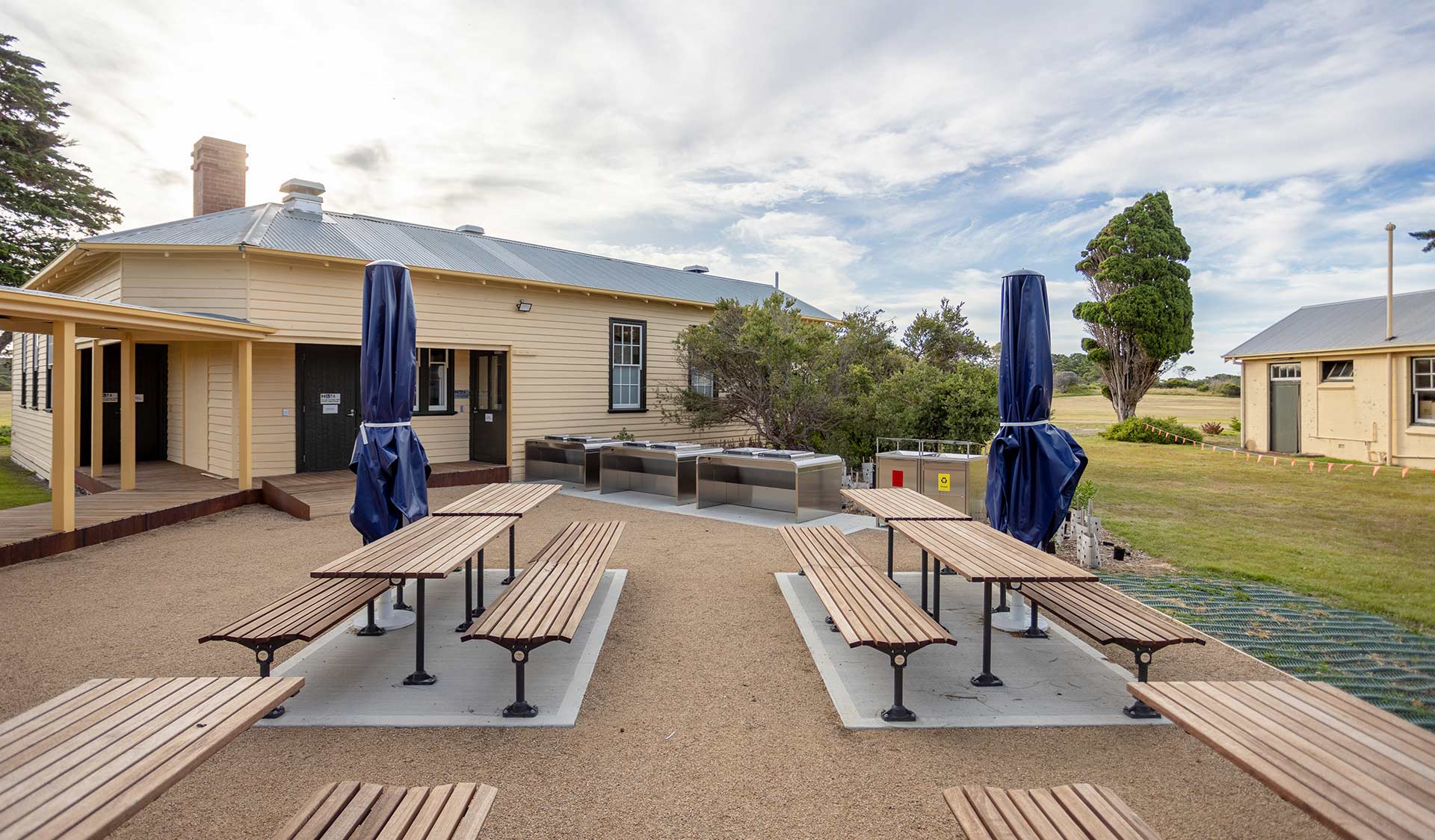 A bbq area with several tables in a coastal landscape.
