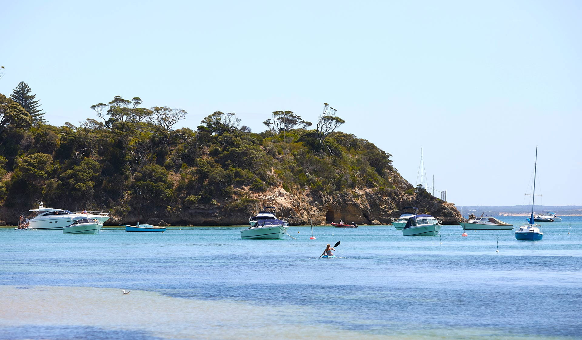 A woman paddles a kayak on Port Phillip Bay near Portsea