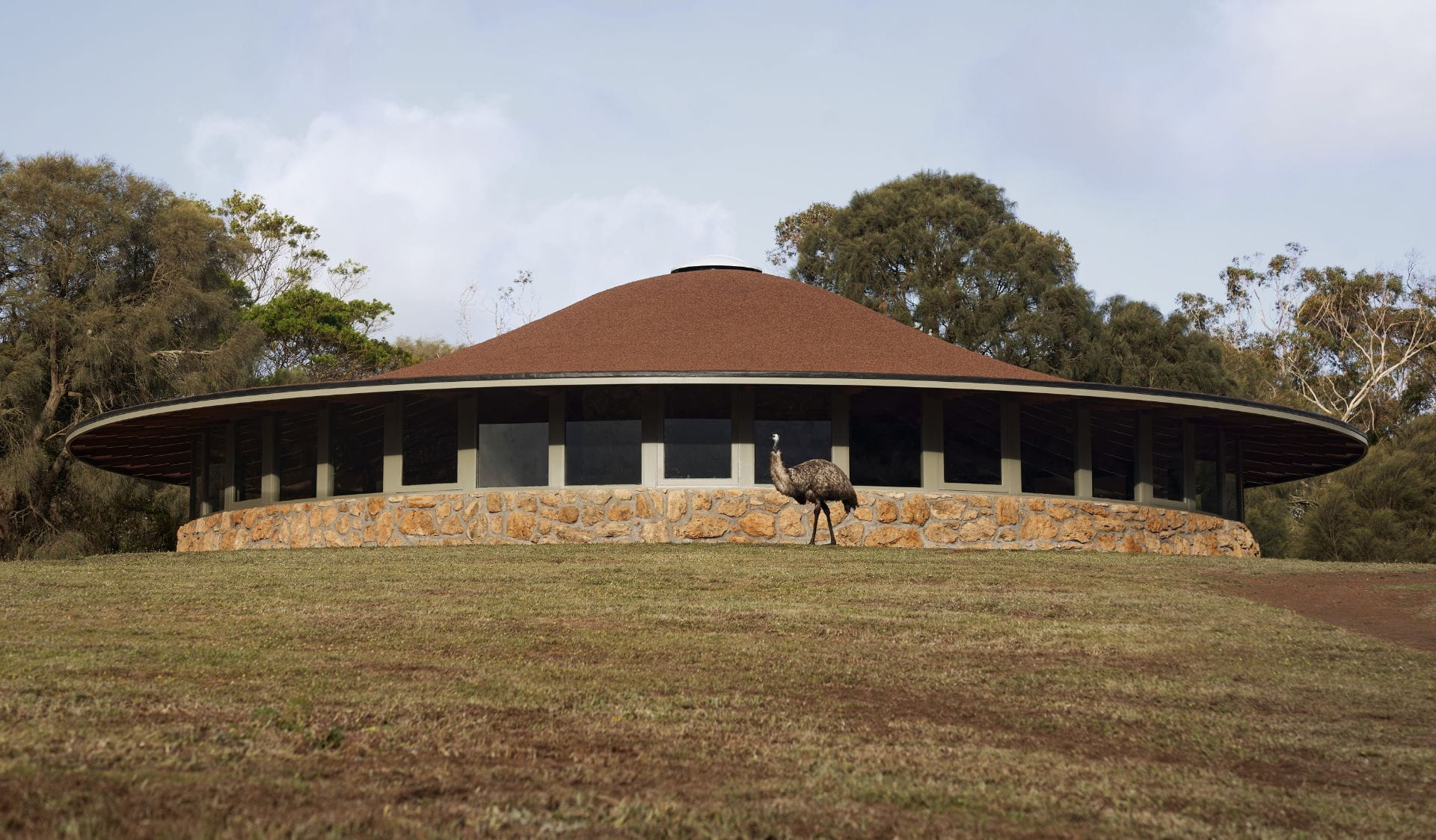 An emu in front of the newly refurbished Tower Hill visitor centre building with a dome-shaped roof. 