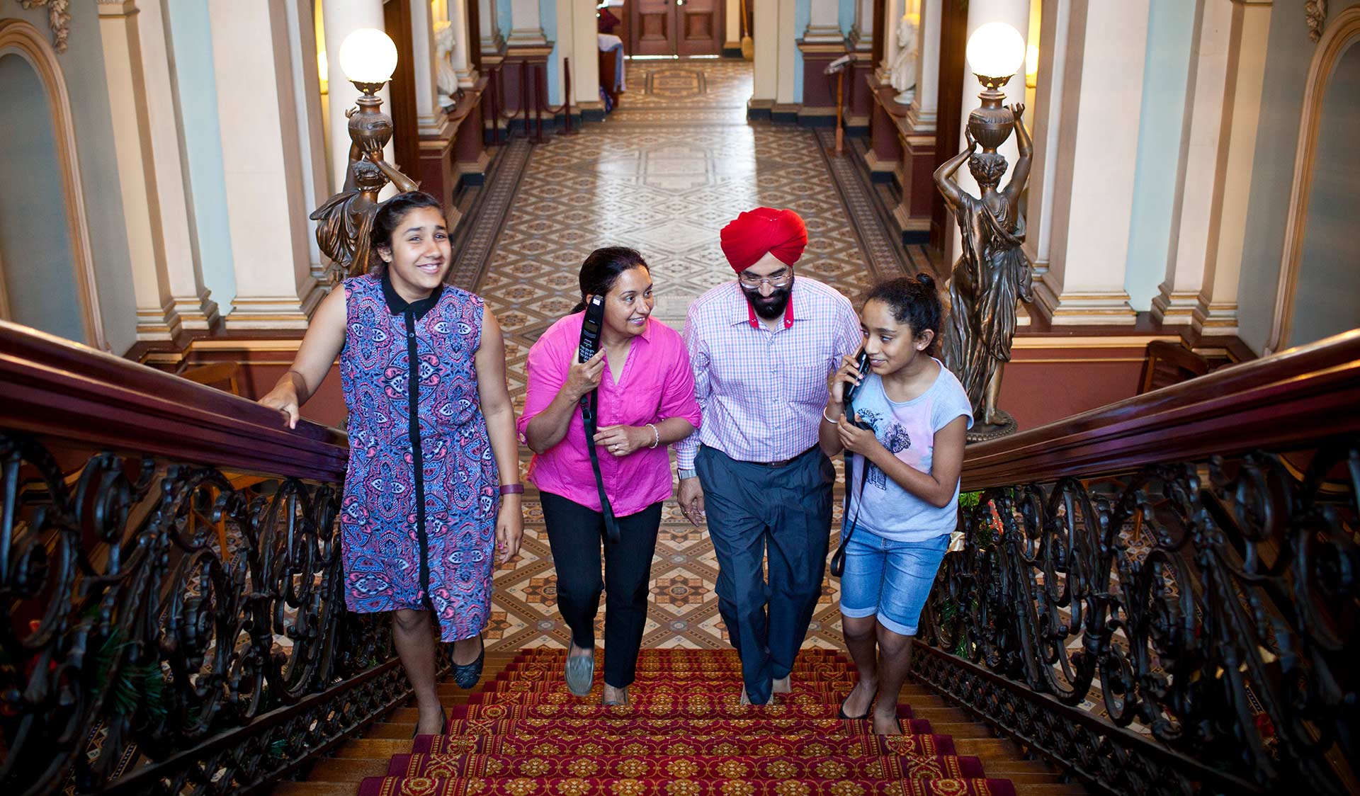 A family walk up the grand staircase in the historic Werribee Mansion.