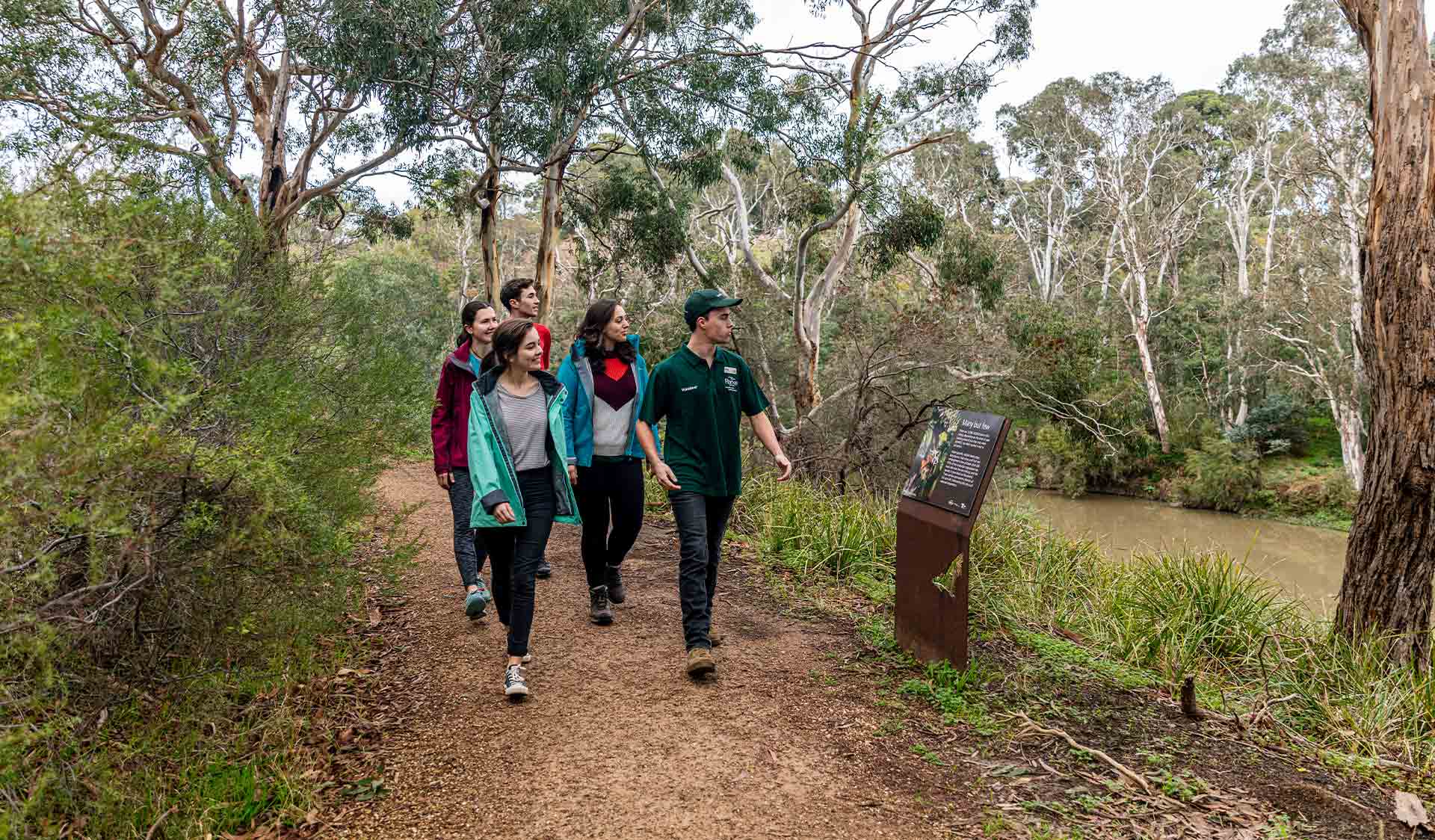A group take a volunteer led tour through the Flying Fox environments on the banks of the Yarra River in Yarra Bend Park