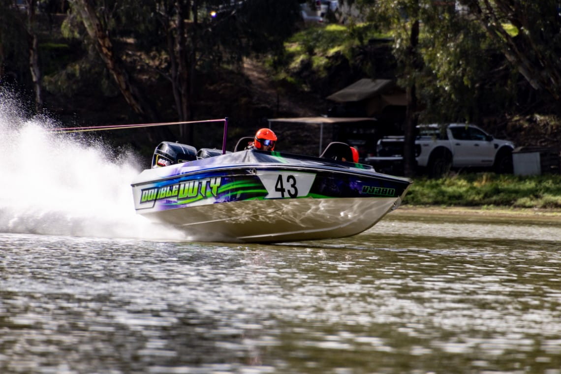 a speedboat, number 43, ridden by two people in helmets and safety equipment