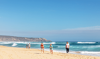 A family walking on Gunnamatta Beach in Mornington Peninsula National Park