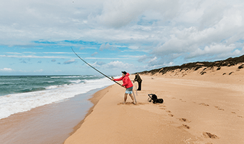 Two men surf fishing at Ninety Mile Beach in Gippsland Lakes Coastal Park