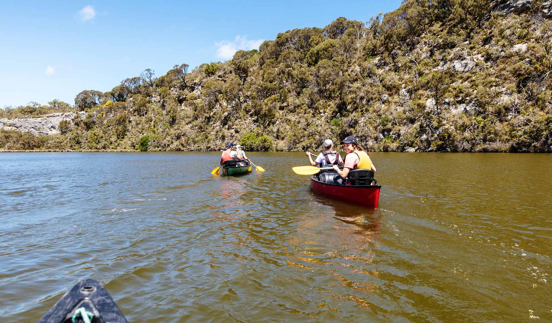 Two canoes paddle down the Glenelg River in the Lower Glenelg National Park.
