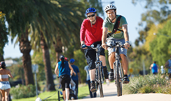 Two men ride bikes along a track in Maribyrnong Valley Parklands