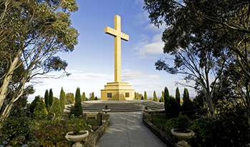 The memorial cross against a blue sky at Macedon Regional Park
