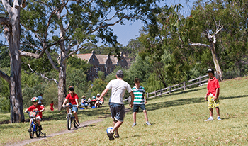 A family plays soccer while kids ride bikes at Yarra Bend Park