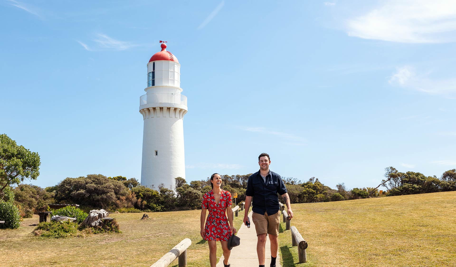 A couple walk down the track and away from the Lighthouse at Cape Schank on the Mornington Peninsula.