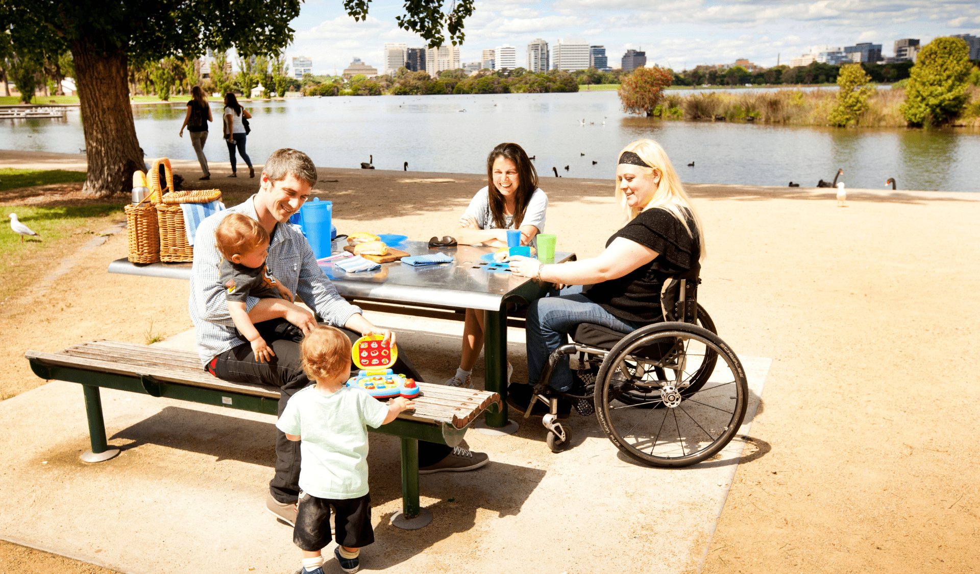 Family sitting at an accessible picnic table near lake