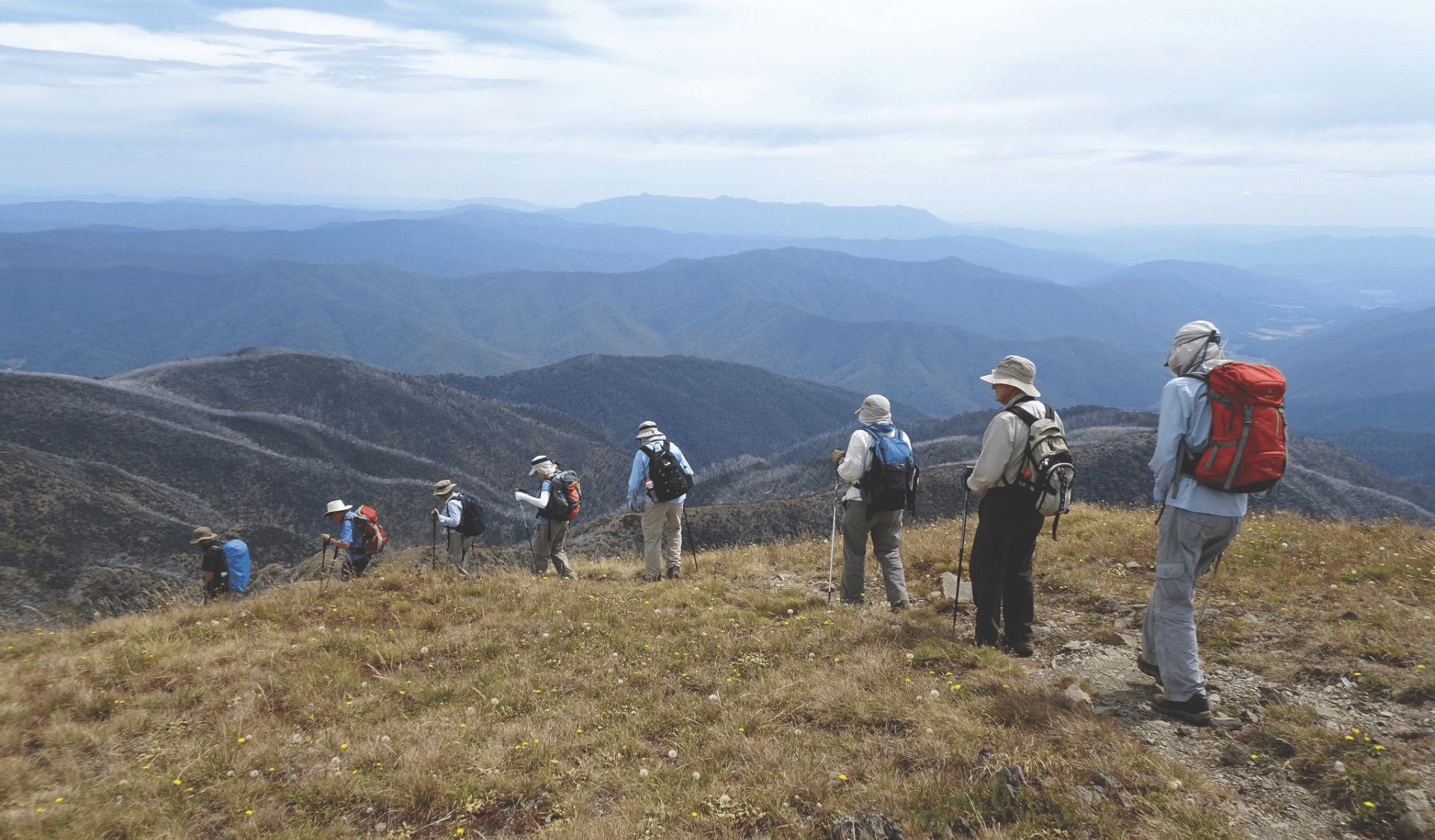 Group of hikers following path along mountains.