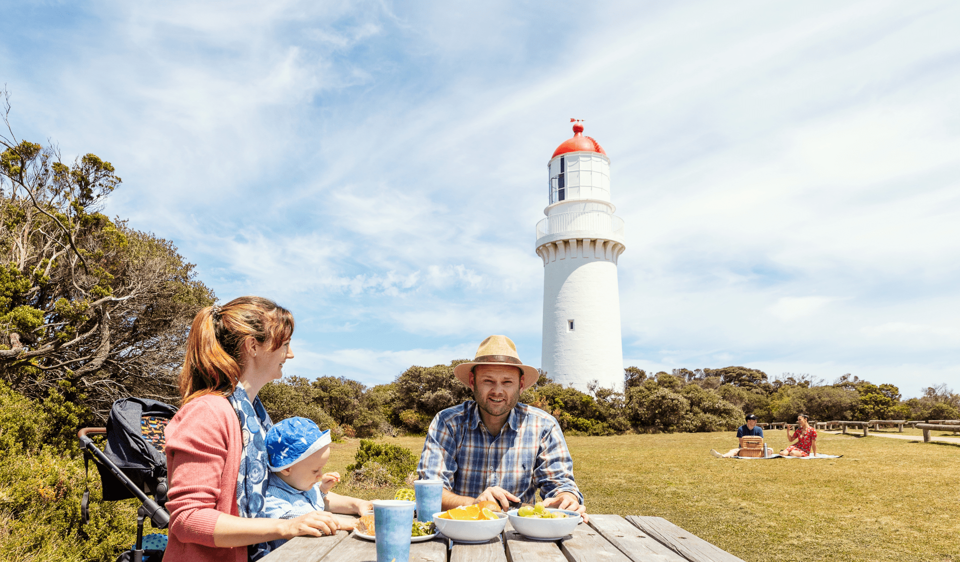 Family enjoying a picnic on a table near Cape Schanck lighthouse.