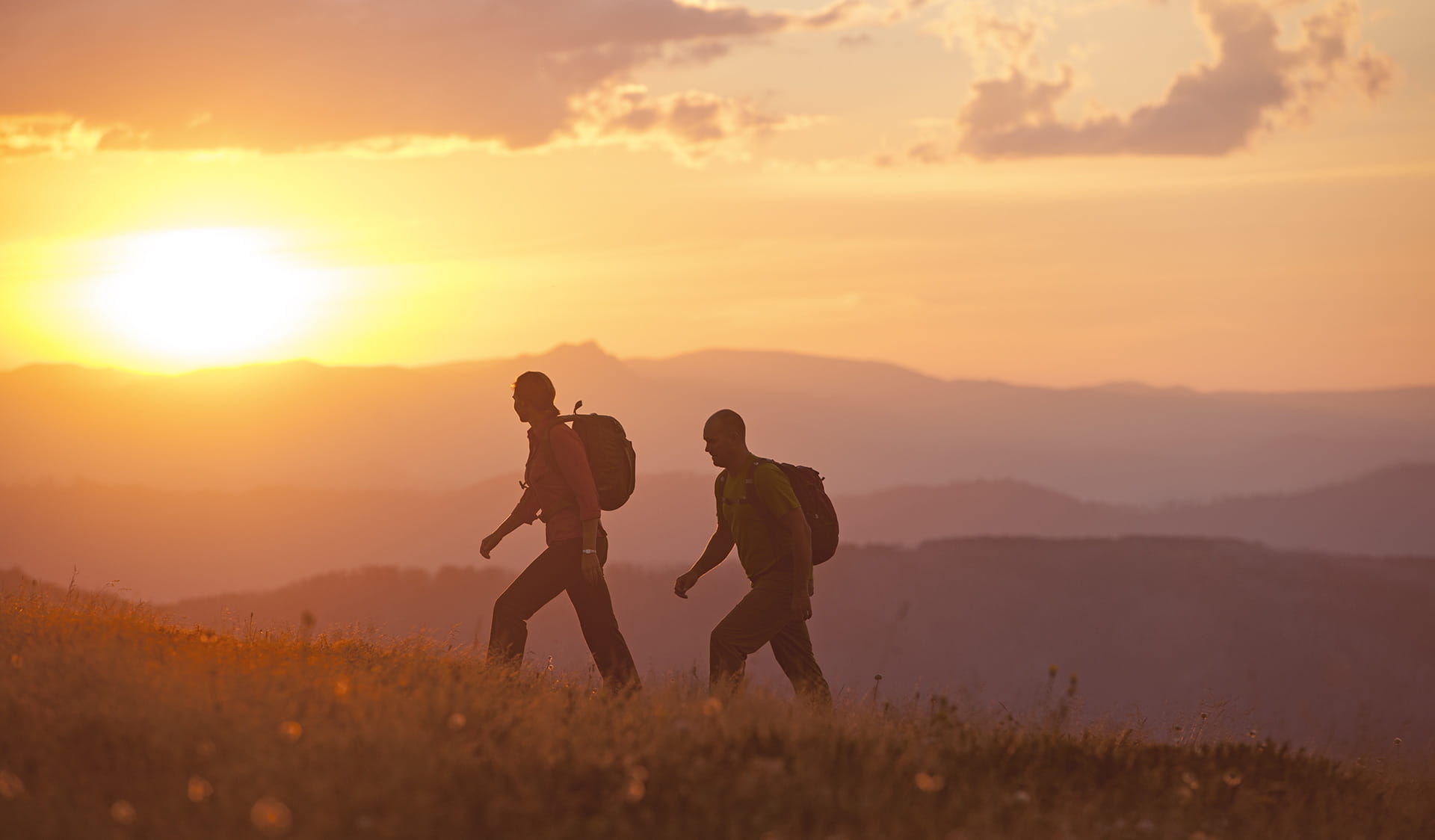 Two walkers head across the Razorback near Mt Feathertop at Sunset.