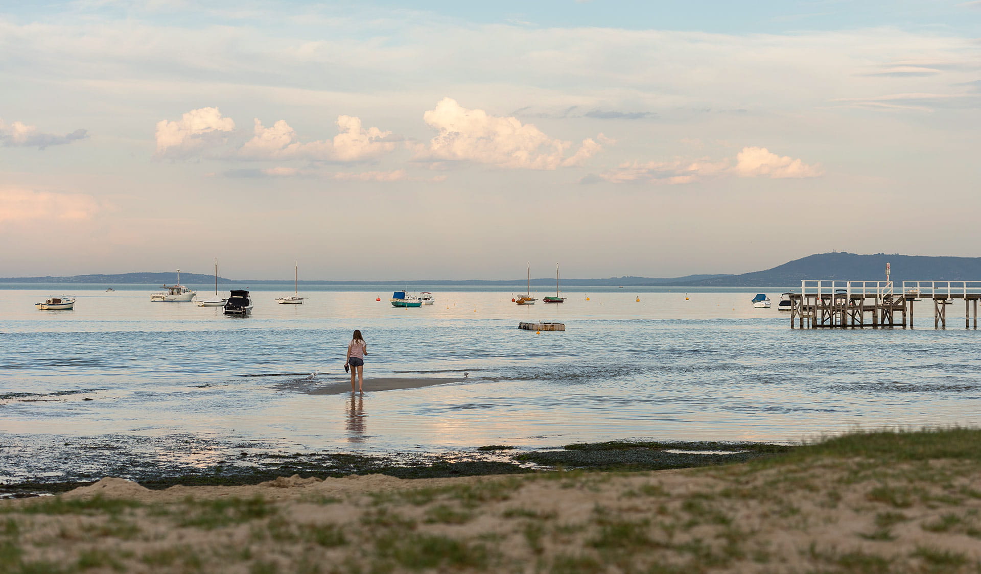 A women stands on a mud flat near the Sorrento Foreshore.